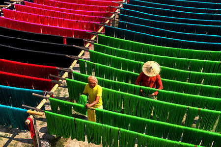 Weavers rinse colourful Jute fiber to dry under the sun which will be used to extract threads to make handloom dresses. The saree is a traditional form of dress for women in India. In Shantipur & Fulia in the Nadia district of West Bengal, India, 90 % of the population has been engaged in weaving activities for generations.