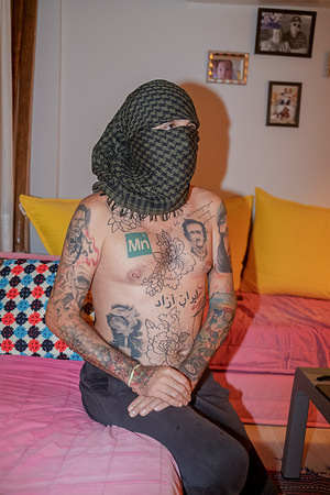 A young man poses with a tattoo that reads “Freedom for Iran” in Farsi. A young man with his face covered poses with a tattoo that reads “Freedom for Iran” in Farsi to draw attention to the ongoing protests in Iran and show support for the Iranian people.