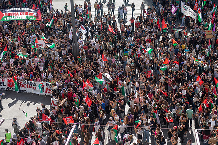 Panoramic view of Puerta del Sol with dozens of protesters carrying banners and flags during a general strike called by Spanish unions in solidarity with the Palestinians in Gaza.