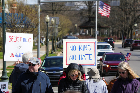 Protesters gathered at Riverfront Park for a “No Kings” protest against the Trump administration and its policies; participants held hand-lettered placards and American flags. Organizers said the local rally was one of more than 3,300 sister demonstrations held nationwide.