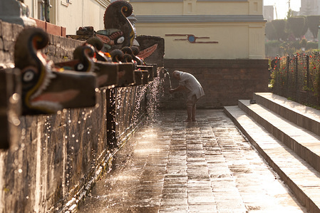 KATHMANDU, NEPAL - APRIL 8, 2020:
A man wearing a face mask offers prayers during the Balaju Baise Dhara festival on the sixteenth day of the nationwide lockdown in Kathmandu.