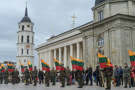 Lithuanian servicemen stand in the guard of honor while holding Lithuania flags during the solemn ceremony in honor of the National Flag Day on the Cathedral Square in Vilnius. Every year on January 1st, Lithuania commemorates January 1, 1919, when a group of volunteers first raised the red-yellow-green tricolor as a symbol of free Lithuania on the tower of Gediminas Castle.