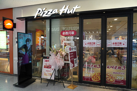 A Pizza Hut storefront with promotional signs and a "Quick Pickup" service display.