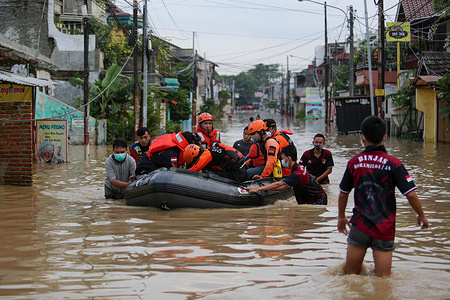 Volunteers carry flood victims using rubber boats during the evacuation.
Due to heavy rains in the past few days inundated the city of Jakarta, and the area around the outskirts of the city.