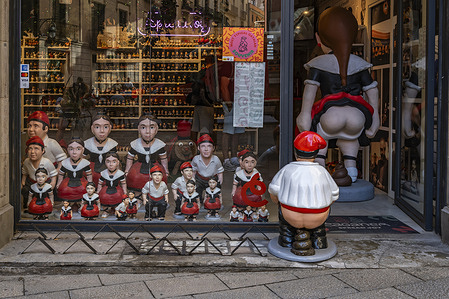 A view of a display window at a store selling traditional nativity scene figurines filled with “caganers” figurines relieving themselves.
