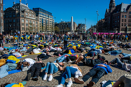 Protesters are seen lying on the ground while playing dead during the demonstration. The Ukrainian community in The Netherlands performed in the city center of Amsterdam a flashmob to highlight the devastating impact of the ongoing war in Ukraine. Protesters laid on the ground playing dead to protest the violence and rising death toll in Ukraine and to demand further sanctions on Russia.