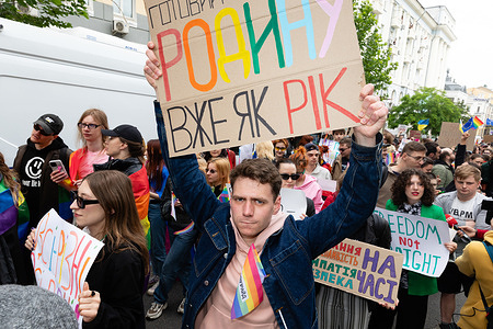 A group of people march in a pride parade holding placards with Ukrainian and English messages during the KyivPride. The March of Equality is a key event of Kyiv Pride 2025. Over 1,500 people participated under the slogans "Together for Equality, Victory" and "Unity in Diversity." The event's goals were to protect the rights of the LGBTQ+ community including the legalization of civil partnerships as well as to support LGBTQ+ military personnel and raise funds for the Ukrainian Armed Forces (AFU). This was the first time the March of Equality combined a human rights action with charity. Participants included LGBTQ+ military members, activists and diplomats such as the EU Ambassador and the Canadian Ambassador.