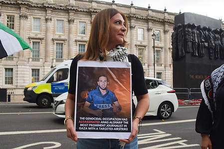 A protester stands with a photo of Anas Al-Sharif, the Al Jazeera journalist killed in Palestine, during a vigil outside Downing Street. The vigil was organised by the National Union of Journalists (NUJ) in remembrance of Palestinian journalists killed by Israeli forces, and in protest against the killing of journalists in Gaza.