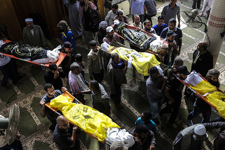 (EDITOR’S NOTE: Image depicts death)
Palestinian mourners carry out the bodies of Rasmi Abu Malhous and seven members of his family during their funeral at a mosque in Deir al-Balah, central Gaza Strip. The deceased were killed in an overnight Israeli missile strike that targeted their house.