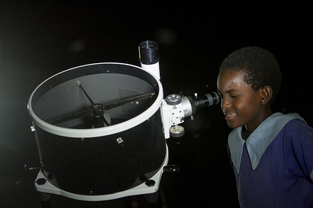 A Kenyan girl seen looking through a telescope.
People witness the Lunar Eclipse in Oloika Town, Magadi, Kenya. The Moon completely covered the Earth's umbra on the night of 27th July 2018 for 103 minutes, making this eclipse the longest total lunar eclipse of the 21st century.