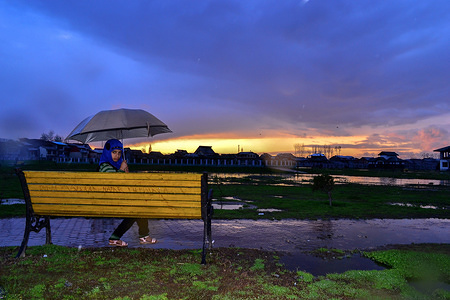 A girl with an umbrella poses for a photograph as it rains in Srinagar, Indian administered Kashmir. A fresh spell of rainfall lashed the plains of Kashmir while the higher reaches received moderate snowfall on Saturday.
An official from the met department said that inclement weather is likely to continue during the next 24 hours.
