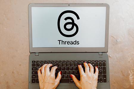 In this photo illustration, the Threads logo is displayed on a laptop screen.