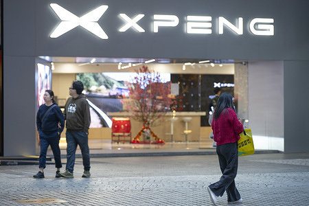 Pedestrians walk past the Chinese EV automaker brand, Xpeng, store in Hong Kong.