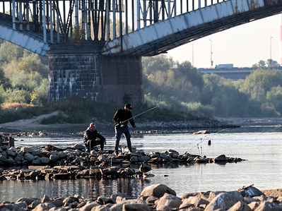A fisherman catches fish at the muddy banks of Vistula river as water levels hit historic lows due to hydrological drought. The hydrological measurement showed only 11 centimeters.