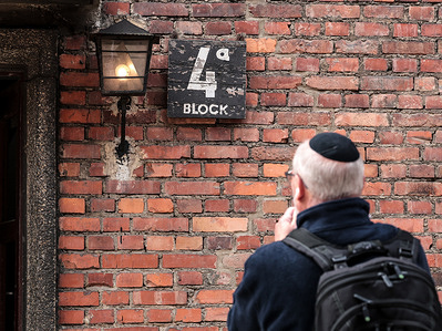 A participant takes photo of Auschwitz camp building in Auschwitz Museum - former Nazi German Concentration Camp during the International March of the Living (MOTL). MOTL in an educational event and takes place on Holocaust Memorial Day observed in the Jewish calendar (Yom HaShoah), thousands of participants march silently from Auschwitz to Birkenau - an extermination camp. It traditionally gathered Holocaust survivors, but today other antisemitism attack survivors  attend the march.