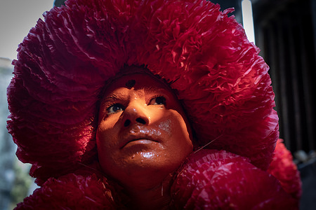 A devotee poses for a photo before the Lal Kach procession on the very last day of Bangla year. The Hindu men paint themselves with red color and attend a procession holding swords as they show power against evil sprits in the very last day of Bangla calendar and welcoming another Bangla New Year.