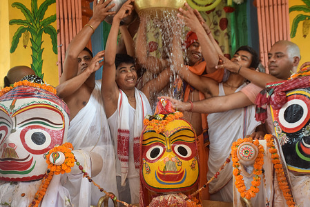 Hindu priests pour milk over a statue of Jagannath during the Snana Yatra procession. 
The Snana Yatra is a bathing festival celebrated on the Purnima (full moon day). It is an important festival of the Jagannath devotees. It is the birth day of lord Jagannath.