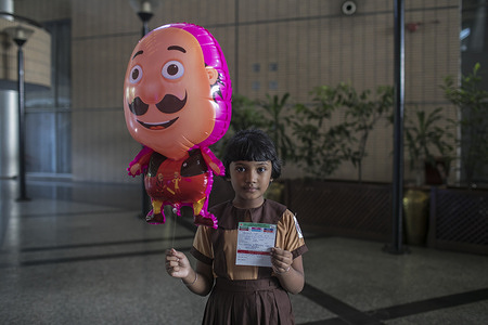 A girl shows her vaccination card after receiving a dose of Pfizer-BioNTech covid-19 vaccine at Bangabandhu International Conference Center. Bangladesh has started administering coronavirus vaccines to students aged from 5-11 years.