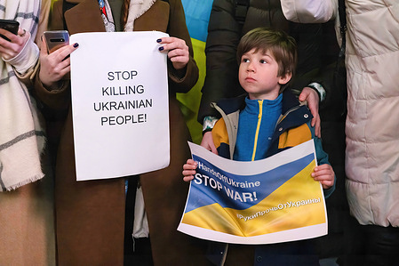A protester stands next to a child holding a placard reading "Stop War" during a demonstration against Russian invasion of Ukraine.As a response to the Russian invasion of Ukraine a small group of protesters gathered in Shibuya Crossing in the center of Tokyo to protest the war.