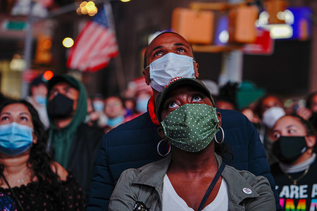 People are seen emotional as they watch the ABC Good Morning America GMA Studios video screen as president-elect Joe Biden gives his acceptance speech from Delaware, in Times Square, New York on November 7, 2020. - Democrat Joe Biden has won the White House, US media said November 7, defeating Donald Trump and ending a presidency that convulsed American politics, shocked the world and left the United States more divided than at any time in decades.