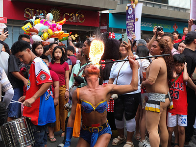 A fire-eater wearing a superhero outfit blows fire by inserting a metal stick to his mouth. Filipinos celebrate Chinese or Lunar New Year in Manila Chinatown by buying ornaments for good luck, watching fire-eaters performances and lighting incense. They believe it will bring luck and prosperity.