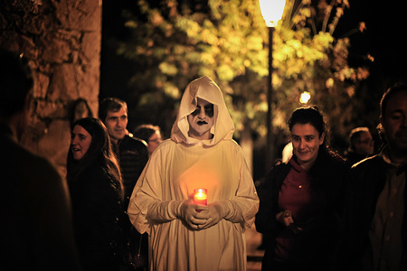 An Almeta holds a candle during the celebration of the act of Almetas y Totones in the village of Radiquero, Huesca, Spain.
All Saints Day is a tradition celebrated in the small village of Radiquero. A group of people called "Almetas" dressed in white carrying candles where they represent the journey of souls on the day of all saints. They offer candles in exchange for taking the soul of the living. They walk the streets of the village ending up in the village cemetery, this year suspended due to heavy rains in the region.