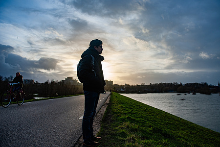 A man is seen looking at the high water level from the Waal River in one of the dikes. The rainy Christmas Days have caused significant inconvenience throughout the Netherlands. In Nijmegen, low parts of the quay, and around the harbor at the Waalkade are underwater. The water level right now is around 14.60 meters above NAP. (Normaal Amsterdams Peil) NAP is the base used to measure how high or low water levels are. Because it still raining a lot in Netherlands, there is a good chance that the water level will rise again at the beginning of the new year.