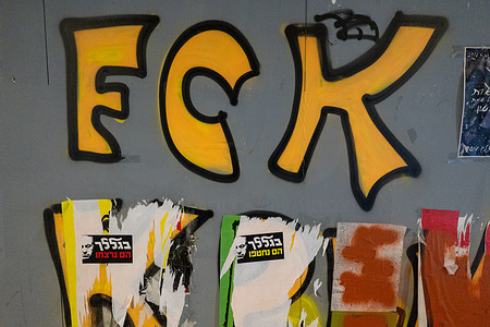 (EDITORS NOTE: Image contains profanity)
Stickers on a wall in Tel Aviv with a photo of PM Benjamin Netanyahu, along with the text: "Because of you they were taken hostage", "Because of you they were murdered" seen during the rally. Thousands of people have gathered in Tel Aviv and other locations in Israel in mass protests, demanding an immediate hostage deal before more hostages are killed by Hamas. The news about the bodies of 6 hostages rescued from Gaza brought many Israelis to the streets, protesting the abandonment of the hostages. Hersh Goldberg-Polin, Eden Yerushalmi, Carmel Gat, Almog Sarusi, Alexander Lobanov, and Ori Danino were alive in captivity for nearly 11 months, before being murdered in captivity by Hamas terrorists soon before IDF forces reached their location, according to an IDF initial assessment. Protesters breached the police's barriers, blocked the Ayalon Highway, set bonfires, and painted graffiti slogans blaming the Israeli government and PM Benjamin Netanyahu for the death of the hostages. During the protests police threw stun grenades into Ayalon to evacuate protesters and re-open the highway for vehicles.