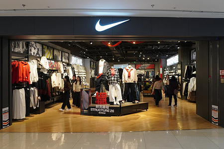 The Nike store features mannequins in sportswear and a "STRUCTURE 26" display, with customers browsing inside.