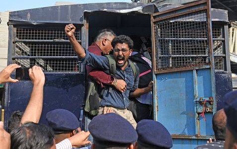 A protestor shouts slogan from a police van after being detained by policemen near August Kranti Maidan (an area in South Mumbai) in Mumbai. Protestors gathered to protest in solidarity with a demonstration in Delhi demanding the resignation of Gyanesh Kumar, Chief Election Commissioner (CEC) of India over allegations of voter list manipulation during the verification of country's voter population under Special Intensive Revision (SIR).
