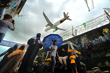 A Vistara passenger jet flies cross over the Jari Mari slum before landing at Mumbai Airport. The re-development of the Jari Mari slum, situated near the airport of the world's third largest city and India's financial capital, has been postponed due to the global economic financial crisis, along with the nearby Dharavi slum.
