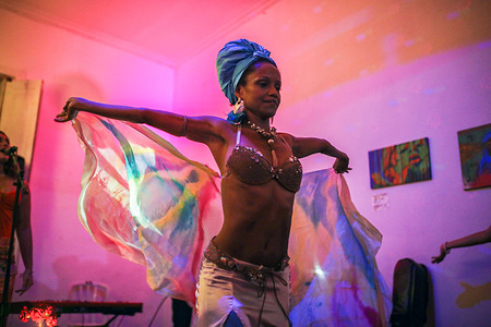 Dária Lorena, a Brazilian visual artist, dancer and choreographer performs a dance at the crossroads of belly dancing and African tribal dances during a pro-Palestine event promoting religious diversity in Rio de Janeiro. These dances pay tribute to African-derived religions by representing the deities (Orixás) Oxum and Iemanjá venerated in Umbanda and Candomblé (two African-Brazilian religions). This performance is an excerpt from the show "Caiçara de Leque" by artist and singer Maha Sati.
