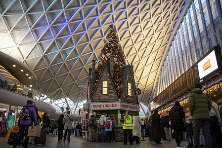 Travellers walk by the Harry Potter Christmas tree on the King's Cross railway station. A Harry Potter Christmas tree was installed at the King's Cross railway station. It was inspired by the Wizarding World of Harry Potter. The installation is 31-foot-tall (9.4 meters) and decorated with hundred of baubles (in Harry's beloved Gryffindor colours), letters from Hogworts addressed to Harry Potter and an owl.