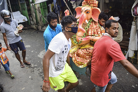 Devotees carrying an idol of Lord Ganesha during the festival amid Coronavirus (COVID-19) crisis.
Ganesh Chaturthi, also known as Vinayaka Chaturthi, is a Hindu festival celebrating the arrival of Ganesh to earth from Kailash Parvat with his mother Goddess Parvati/Gauri. The festival is marked with the installation of Ganesh clay idols privately in homes, or publicly on elaborate mandals.