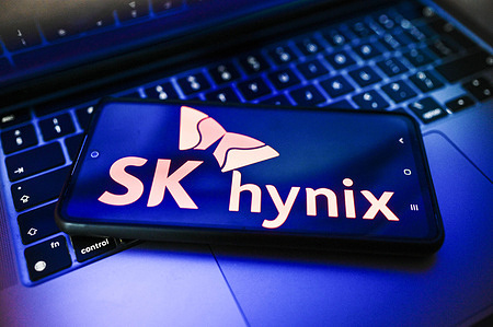 In this photo illustration the SK hynix logo is displayed on a smartphone on the top of a laptop.