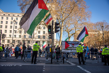 Police officers stand on guard during the Stop Bombing Iran – Hands Off Lebanon – Free Palestine March in London.