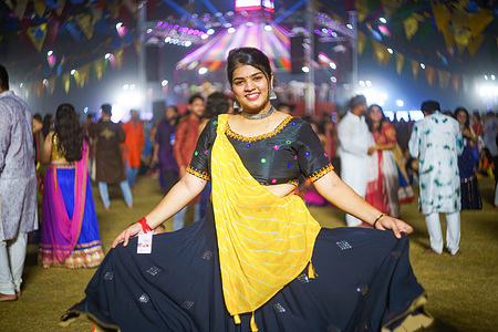 A young Indian woman in traditional clothes seen at the Navratri festival. The Hindu Navratri Festival, lasting 9 nights, is celebrated every year in October all over northern India, especially in the state of Gujarat, to honor the goddess Durga and to celebrate the victory of good over evil. People gather in open grounds to perform together the traditional Garba dance wearing traditional Indian kurta and sari dresses.