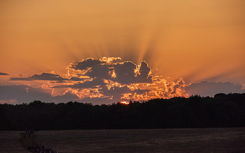 Sunset view during the summer solstice celebration. Revellers gathered by Stonehenge to celebrate the summer solstice. The summer solstice is when the sun is at its furthest point from the Equator and making it the longest day of the year.