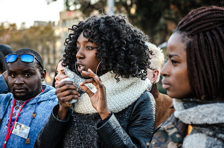 A woman seen reading the manifesto of the concentration against slavery in Libya. Around 300 people have demonstrated against slavery in Libya marching through the Centre of Barcelona. Many of the people who try to reach Europe from Africa are forced to work for their abductors in Libya. Libya is the threshold of Europe where the migrants are waiting to cross the Mediterranean sea.