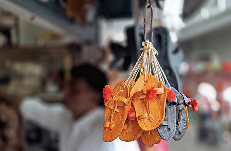 A miniature pairs of Kolhapuri chappals (handcrafted Indian sandal) are on display at a street side shop. Italian luxury fashion brand Prada which launched its 'Toe Ring Sandals' is accused of copying the design inspired by Kolhapuri chappals (handcrafted Indian sandal) without giving due credit to indigenous artisans who created them in Kolhapur district of Maharashtra centuries ago. A Public Interest Litigation (PIL) has been filed in Bombay High Court seeking compensation for Kolhapuri chappal (handcrafted Indian sandal) artisans from Prada.
