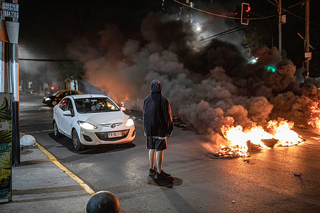A protester seen looking at the burning tires on the street during the commemoration.
Commemoration of the murder of the young brothers Rafael and Eduardo Vergara Toledo in the commune of Estación Central, perpetrated on March 29, 1985 by the agents of the Chilean Police during the military dictatorship of Augusto Pinochet.