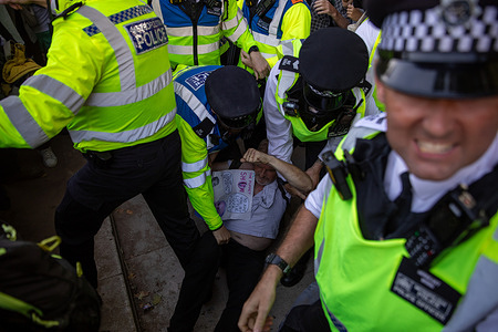 Police officers arrest a Palestine Action supporter during a demonstration. Campaign group, ‘Defend Our Juries’ and ‘Palestine Action’ supporters held a demonstration at Parliament Square calling for the de-prescription of the terrorist group. Up to 1000 activists displayed signs stating they oppose genocide and support Palestine Action. This event became the largest of its kind with many participants expressing support for the designated terrorist group subject to arrest. Alongside supporting Palestine Action, the demonstration sought to overwhelm Police resources. Many of those arrested did not provide their names and addresses resulting in their detention in custody.