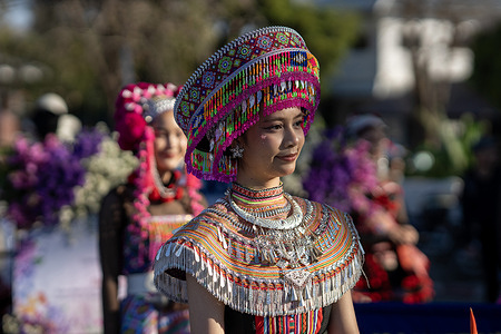 A participant wearing traditional hill tribe attire and an ornate beaded headdress takes part in the 49th Chiang Mai Flower Festival parade in Chiang Mai, northern Thailand. The annual festival showcases cultural performances and elaborate floral displays, attracting large numbers of residents and visitors to the city.