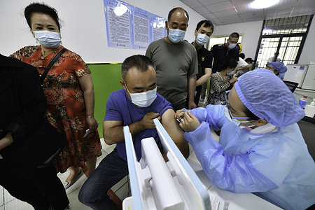 A health worker administers a dose of Sinopharm COVID-19 vaccine to a man at the vaccination clinic of Gulou community health service center in Fuyang City.