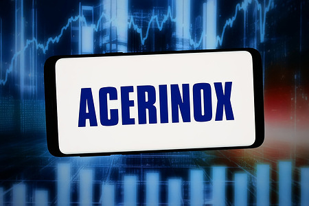 In this photo illustration, the logo of Spanish steel company Acerinox S.A. is seen displayed on a smartphone in front of abstract background on computer screen.