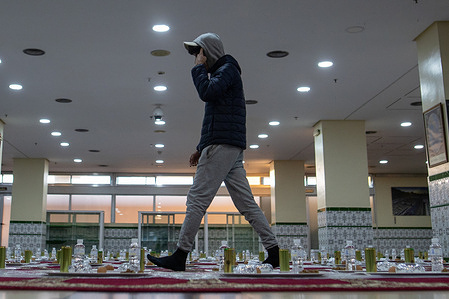 A man walks among portions of food "iftar", the nightly meal which Muslims break their daily fast during the month of Ramadan, celebrated just after sunset (Maghrib) at the M30 Mosque in Madrid.
