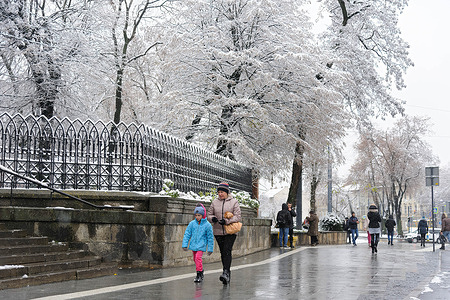 People walk along the street in Lviv. The first snow of this season fell at night. The approach of winter will bring more difficult conditions to Ukraine, including heavy mud, snow, and frost, making operations difficult for both sides in the war. Russia invaded Ukraine on 24 February 2022, triggering the largest military attack in Europe since World War II.