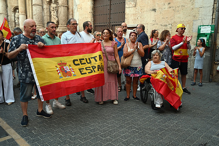 A group of people with a Spanish flag that has a slogan "Ceuta is Spain" seen during the protest against the migration crisis . Around 250 people gathered in El Vendrell, Tarragona, Catalonia, Spain to show support for the city of Ceuta in the face of the migration crisis resulting from the influx of more than 70,000 migrants in July at the border crossing between Spain and Morocco.
