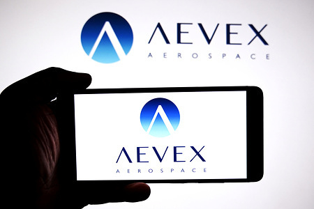 In this photo illustration, the AEVEX aerospace logo is seen displayed on a smartphone and in the background.