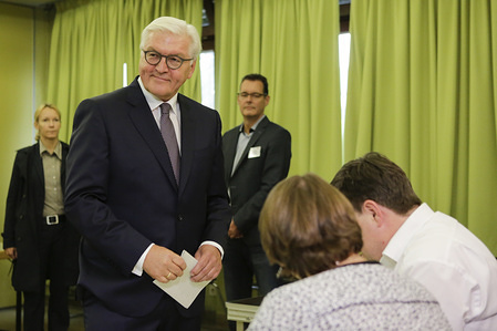 Frank-Walter Steinmeier talks with election officials. The German President Frank-Walter Steinmeier and his wife Elke Büdenbender cast their votes for the German General Election in the Nord-Grundschule in Berlin Zehlendorf.